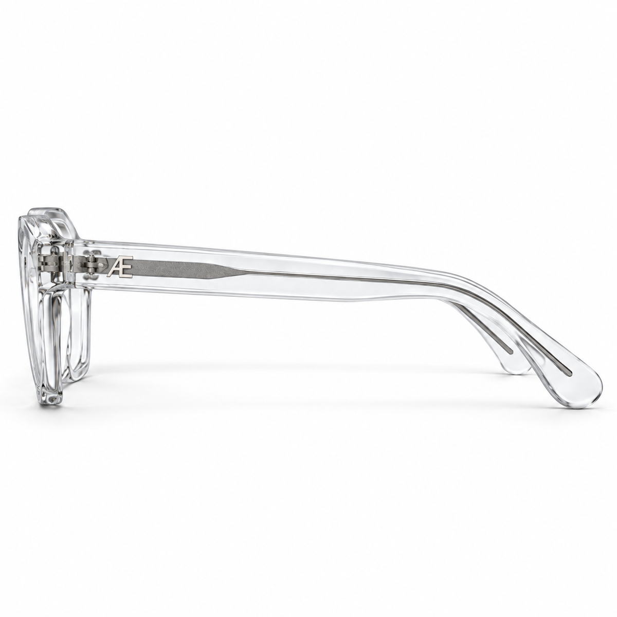 ATÉN Crystal Clear glasses with Everyday Mode lenses with a subtle warm tint in side profile on white, showing the transparent temple and silver core.