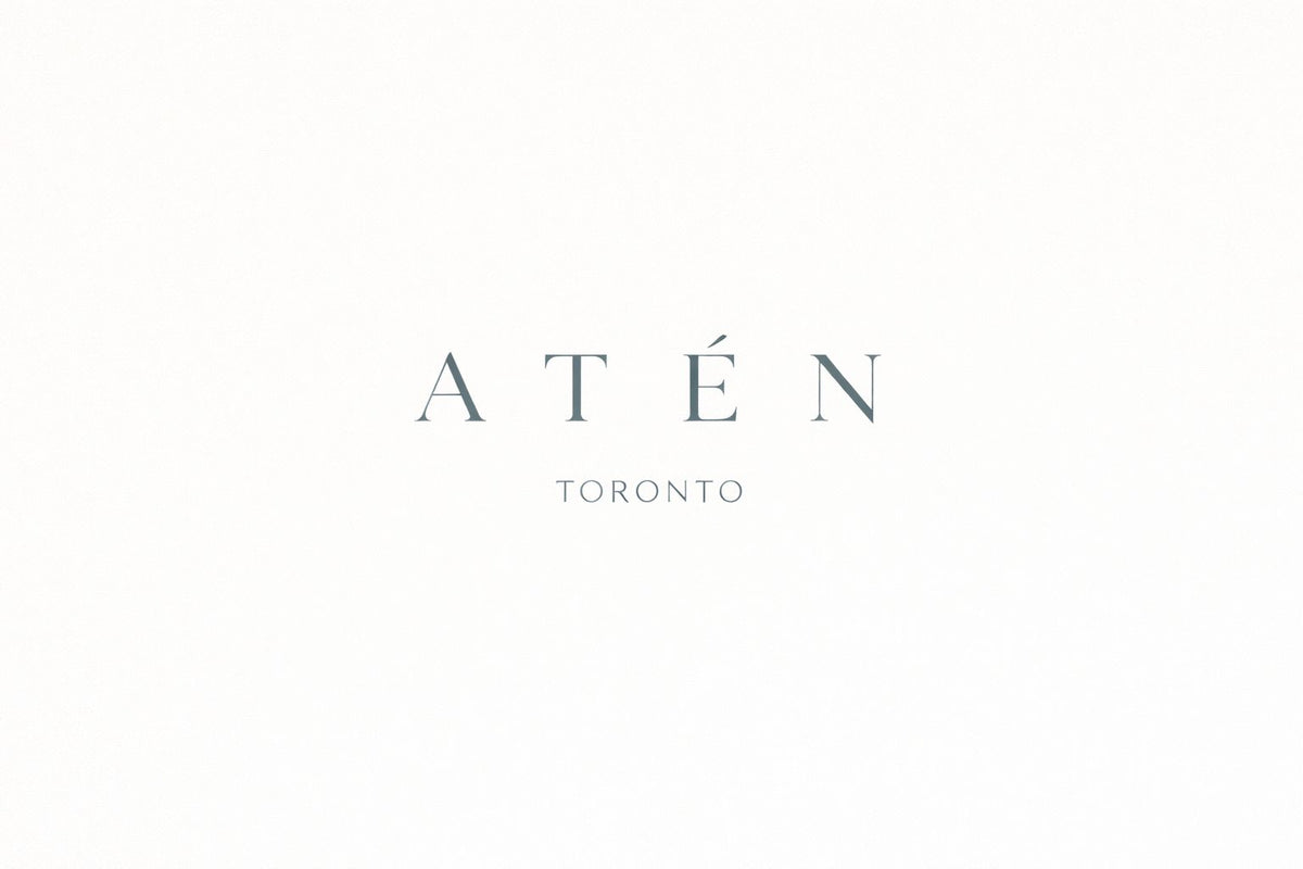 Centered pale blue-gray ATÉN wordmark in widely spaced uppercase serif letters, with an acute accent over the É and smaller uppercase TORONTO beneath, on a plain white background.