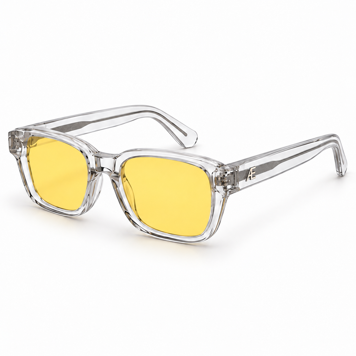 ATÉN Crystal Clear frame with pronounced amber Focus Mode lenses, open three-quarter view, silver cores and monogram on white background.