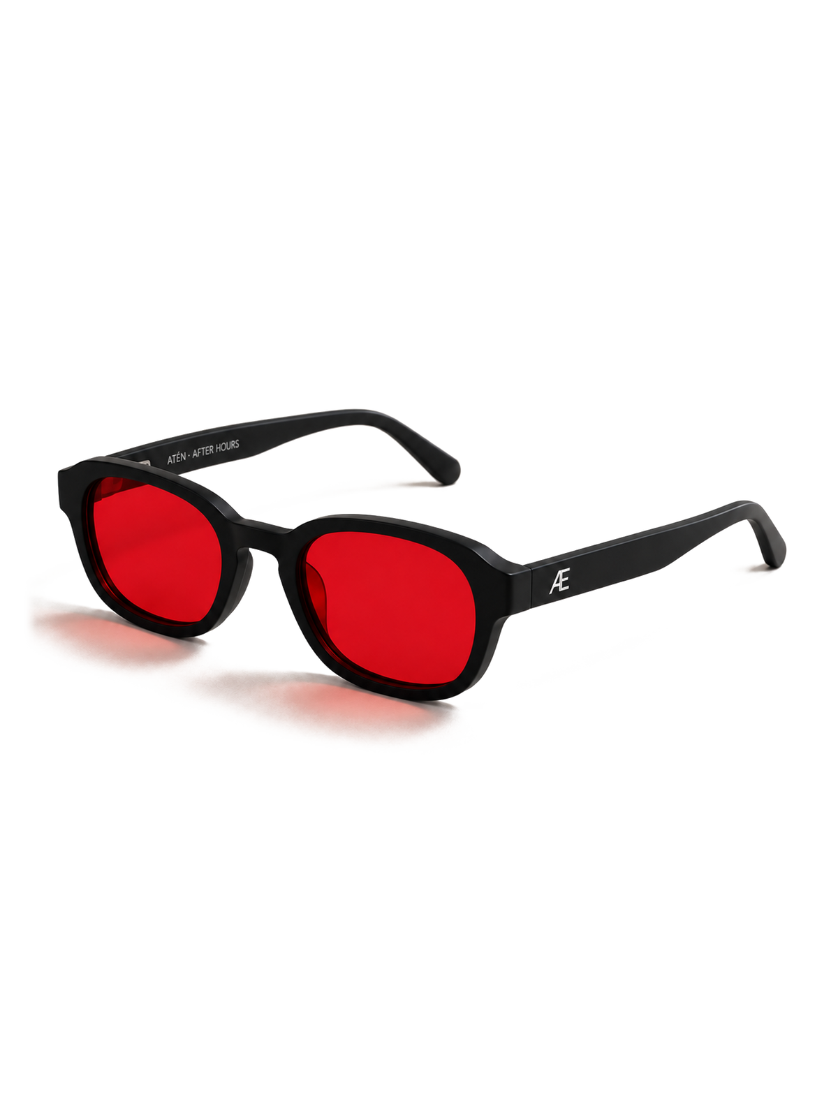 Transparent-background cutout of an open ATÉN matte black frame with deep red After Hours lenses in a front-right three-quarter view. A silver ATÉN monogram is visible on the near temple, the far inner temple reads “ATÉN · AFTER HOURS,” and a soft red cast shadow falls beneath the frame and temple tips.