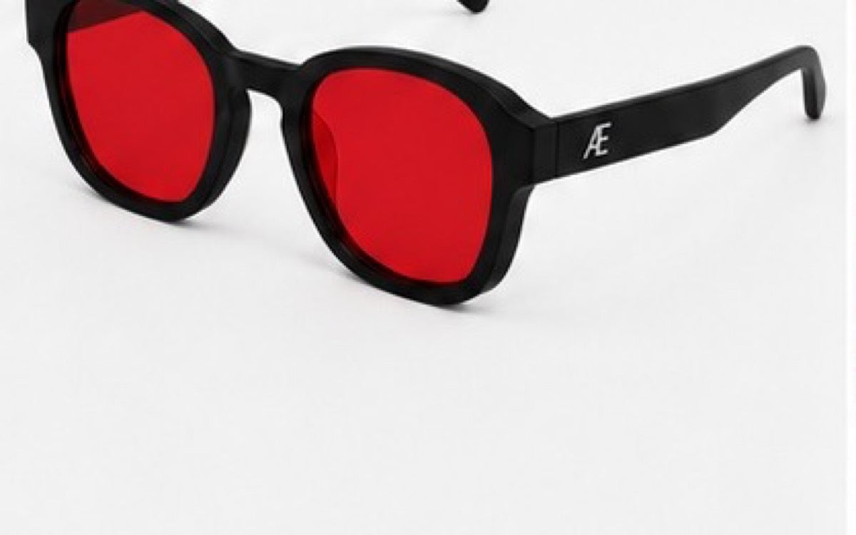 Open ATÉN matte black frame with deep red After Hours lenses in a cropped front-right three-quarter view; silver ATÉN monogram on the near temple, on a white background.