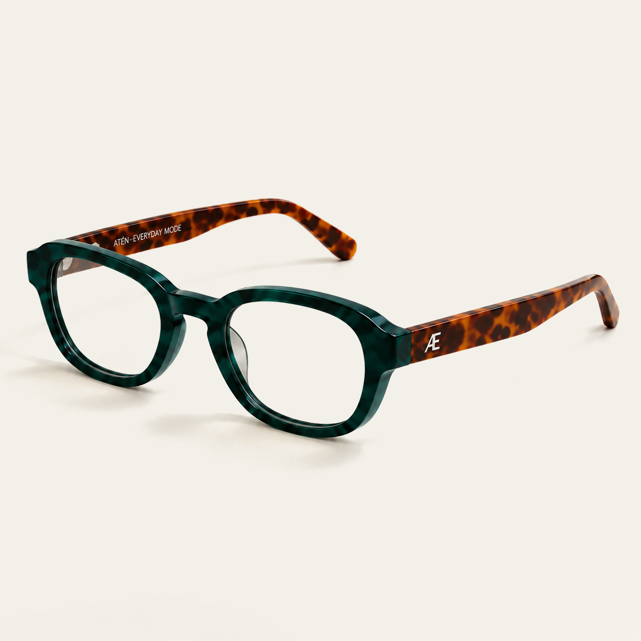 Open ATÉN Forest/Tortoise glasses with Everyday Mode lenses in a front-right three-quarter view; the frame has a deep forest-green marbled front, brown tortoiseshell temples and a silver ATÉN monogram, with both temples open and a soft shadow beneath the glasses on the cream background.